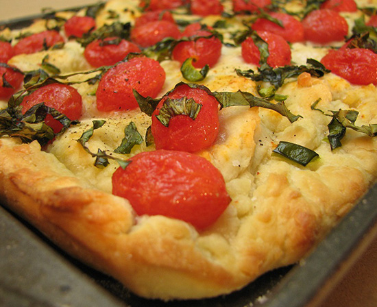focaccia with cherry tomatoes, basil and olive oil